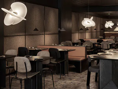 Modern Japanese restaurant interior with dark textured walls, warm wood tables, upholstered chairs, and large sculptural white pendant lights creating a moody elegant atmosphere.