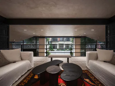 現代客廳室內設計，兩張白色沙發相對擺放，牆面與天花板為深色木質板材，雕塑感黑色茶几置於波斯風地毯上，大型窗戶可眺望庭院花園。