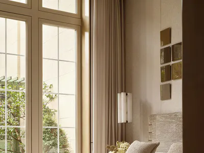A serene contemporary bedroom featuring a bed with textured beige and brown linens, a woven headboard, wall sconce lighting, and large windows overlooking a lush garden.