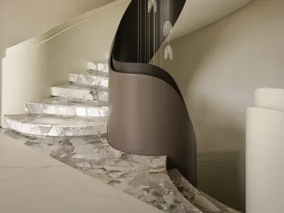 Modern interior featuring a sweeping curved marble staircase with white and grey veining, a dark sculptural central wall, and a long vertical glass pendant light fixture hanging in the void.