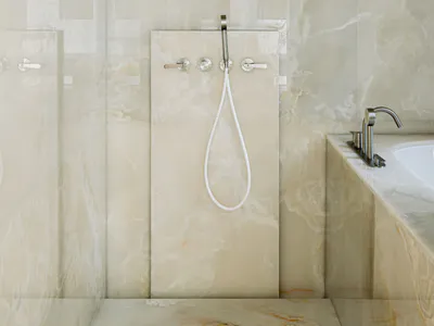 Modern luxury bathroom with large round stainless steel rain shower head, white handheld wand, chrome fixtures, and full-height Calacatta marble walls and floor.