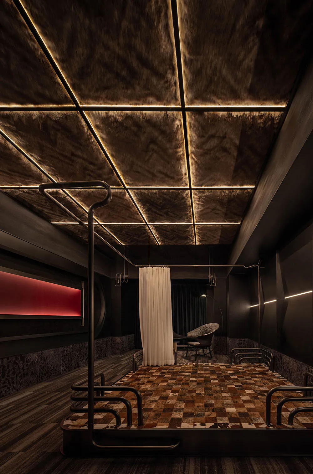 Dark luxury bedroom featuring a black metal four-poster bed, patchwork cowhide leather floor, textured dark walls, and dramatic linear ceiling lighting.