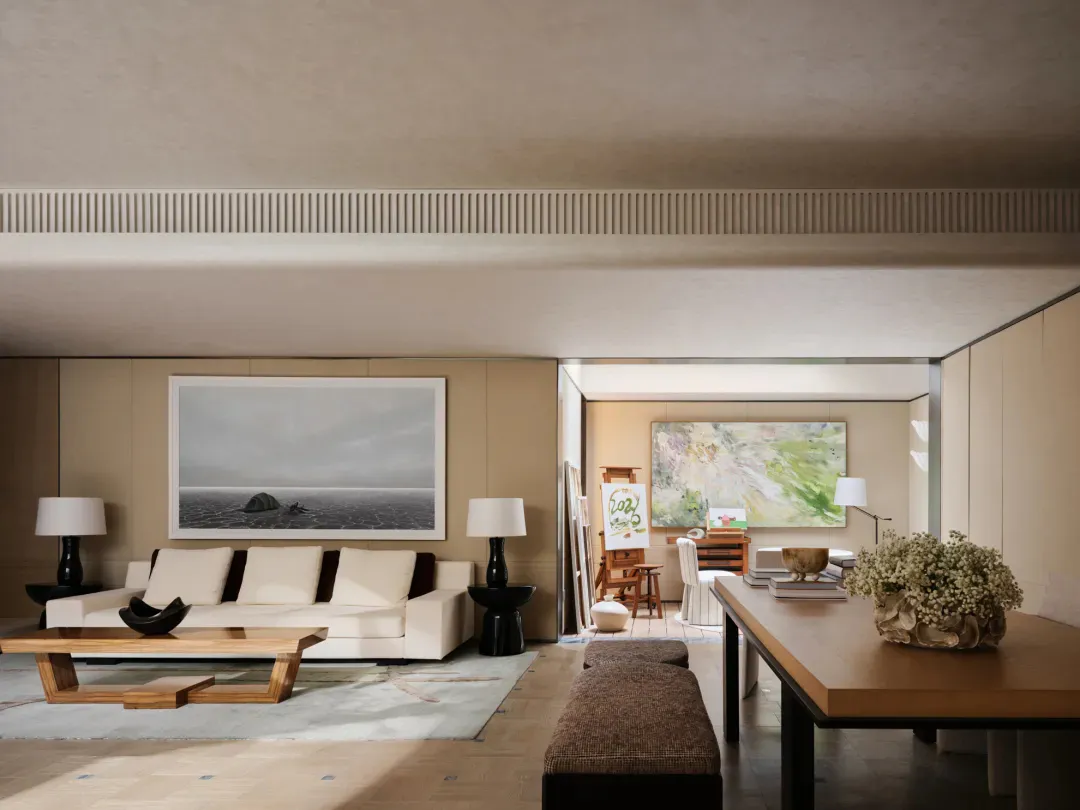 Modern minimalist living room with white sofa, large seascape painting, wooden coffee table, and adjacent dining area with large floral arrangement.
