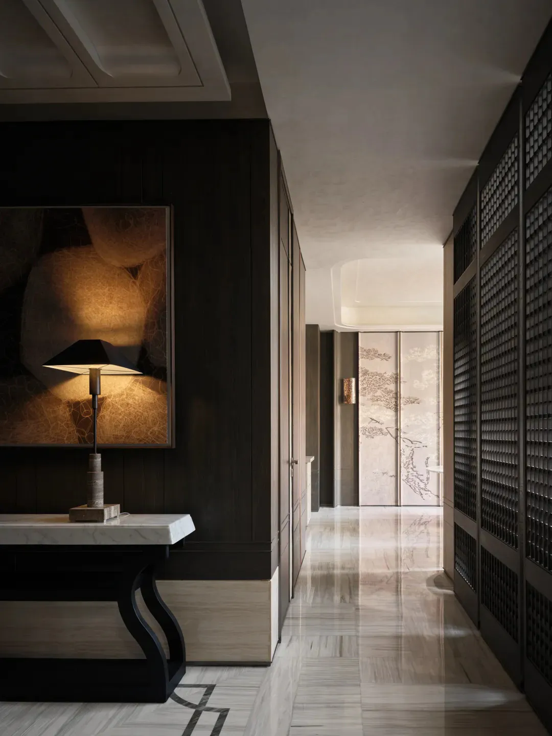 Modern luxury hallway with dark wood walls, marble console table with lit table lamp, large abstract artwork, and Japanese-style pine tree folding screens at the end of the corridor.