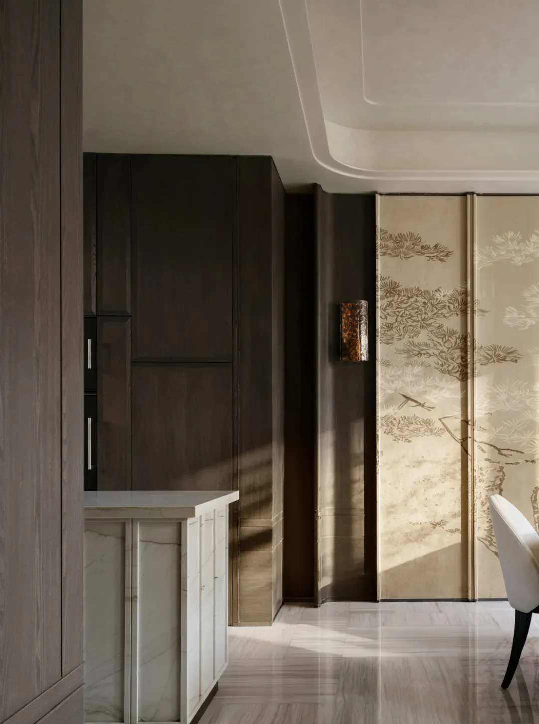 Modern dining area featuring tall dark walnut cabinetry, white marble counter, a tall wall-mounted light fixture, and two large sliding doors with traditional Chinese pine tree ink-wash paintings, paired with a white upholstered dining chair.
