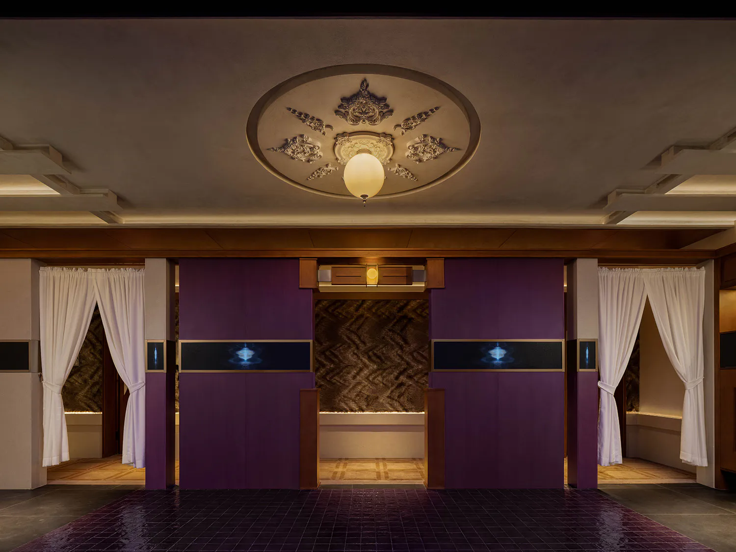 Modern Japanese-style entrance hall featuring rich purple cabinetry, white noren curtains, dark tiled floor, and an ornate circular plaster ceiling medallion with a hanging pendant light.