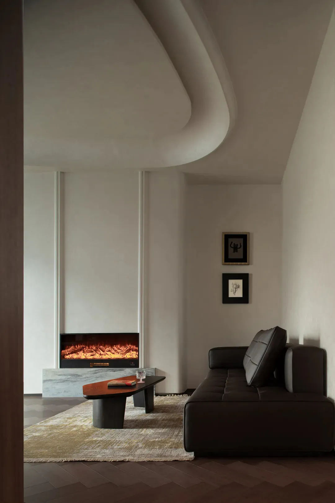 Modern minimalist living room with dark leather sofa, organic curved ceiling, marble electric fireplace, and neutral color palette.