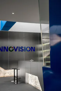 現代科技公司接待區，設有不鏽鋼牆面、藍色 Innovision 品牌標誌，以及發光的電路板主題飾板。