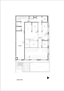 Black and white architectural floor plan of a second-floor office space featuring a kitchen, conference areas, lift, staircases, and multiple void spaces for natural light.