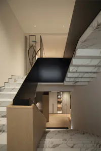 Modern interior view of a floating marble staircase with black risers, light oak handrail, and a minimalist hallway with built-in cabinetry in the background.
