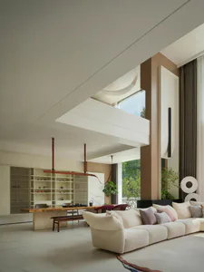 Modern minimalist living room with double-height ceiling, large cream sectional sofa, live-edge oak dining table, and warm neutral walls with large windows overlooking greenery.