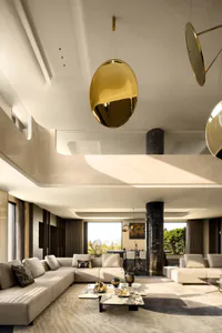 Modern luxury living room featuring a double-height ceiling, large beige sectional sofa, black marble columns, and oversized golden brass pendant lights over a marble coffee table.