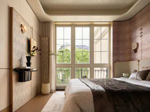 Modern luxury bedroom interior with large windows overlooking greenery, curved ceiling, textured beige and dusty rose walls, upholstered bed with dark velvet throw, and minimalist wall sconces.