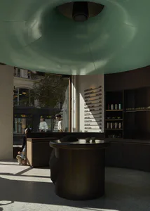 Modern minimalist cafe interior with a large curved mint-green dome ceiling, dark terrazzo counter, menu board listing coffee drinks, and a person with a small dog near the entrance.