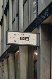 OB 62 Pitt Street 發光時鐘招牌，以極簡字體設計，安裝在大理石與玻璃的建築立面上