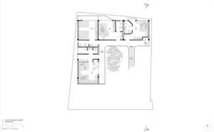 Black and white architectural floor plan of a first-floor residential layout showing four bedrooms, built-in storage, bathrooms, and a large central courtyard with mature tree.