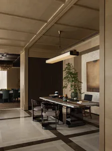 Modern luxury dining room with a long marble dining table, dark wood chairs with upholstered seats, a large potted tree, and dark cabinetry in the background.