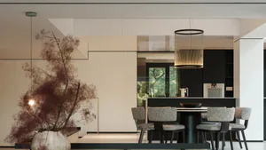Modern minimalist dining room with black kitchen island, round pendant light, four textured grey dining chairs, and large dried floral arrangement in a ceramic vase.