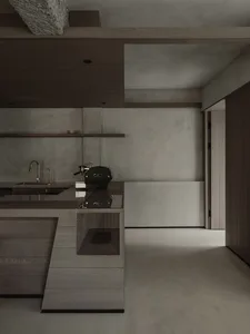 Modern minimalist kitchen with a concrete and wood island, integrated espresso machine, wall-mounted faucet, and open concrete walls with wooden ceiling beams.